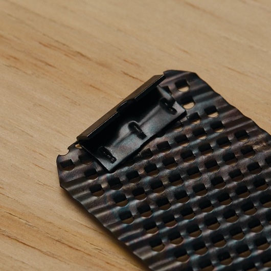 Photo of STANLEY 21-398 replacement surform blade with perforated metal surface, close-up angle on wood background.