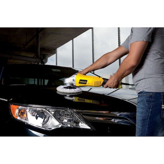STANLEY STGP1318K polisher used on car hood, yellow housing, automotive tool in action.