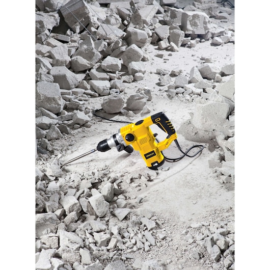 STANLEY STHR1232K rotary hammer drill on rubble, yellow and black, power tool in construction setting