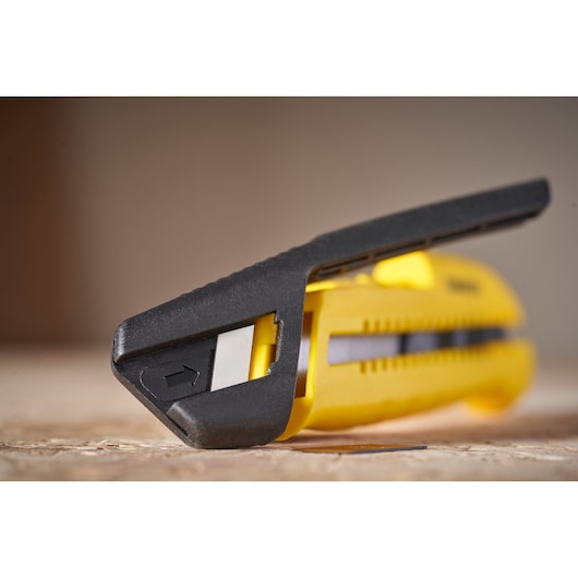 Close-up photo of STANLEY STHT10489 yellow and black utility knife on a flat surface.