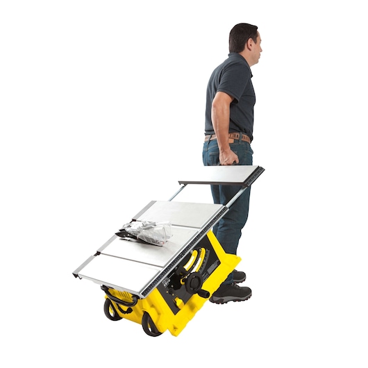 STANLEY STST1825 table saw being wheeled by a person, side angle, yellow body, silver tabletop.