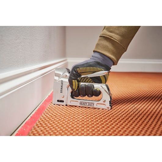 Photo of STANLEY TR110 heavy duty staple gun used for carpet installation, close-up angle.